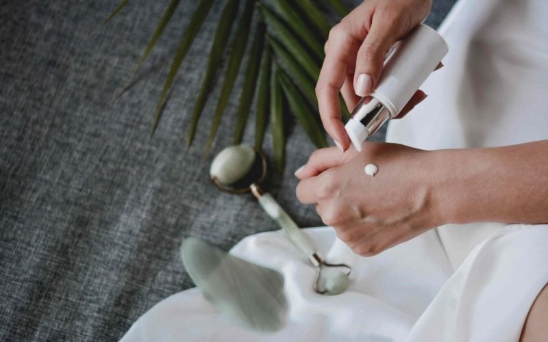 Dispensing skincare lotion from a bottle onto the wrist, essential for a beginner's skin care routine.