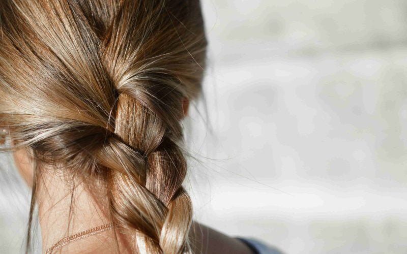 Close-up of a woman's braided hair showcasing the effects of hair volume boosting ingredients.