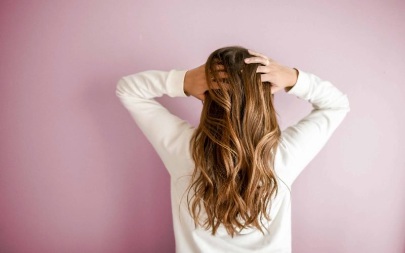 Woman showcasing her healthy hair as part of a sulphate and paraben-free hair care routine.