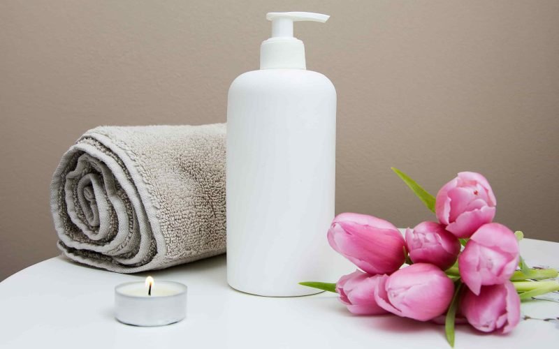 Daily Skin Care Routine essentials including a towel, lotion bottle, and flowers.